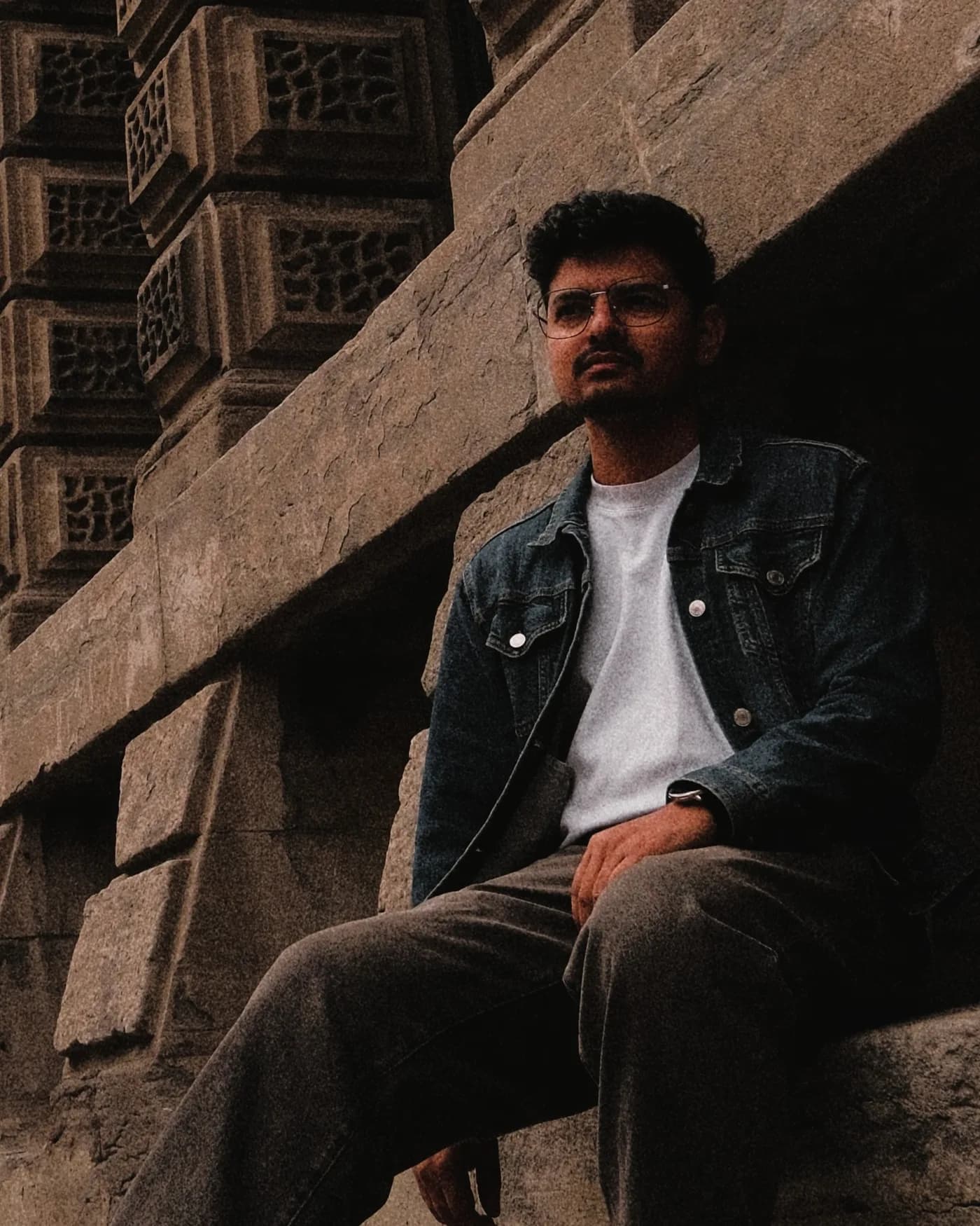 Prajwal Luitel, seated against a stone wall